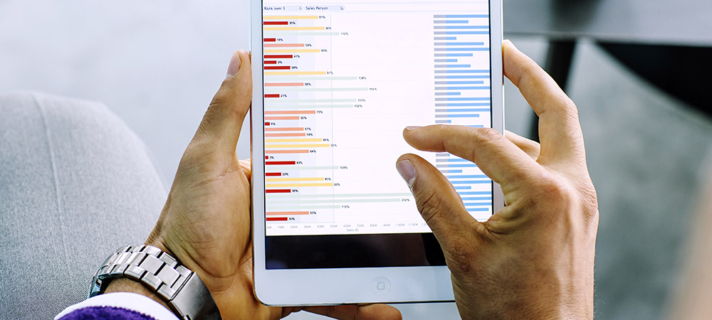 image of Mixed race businessman examining graph on digital tablet.