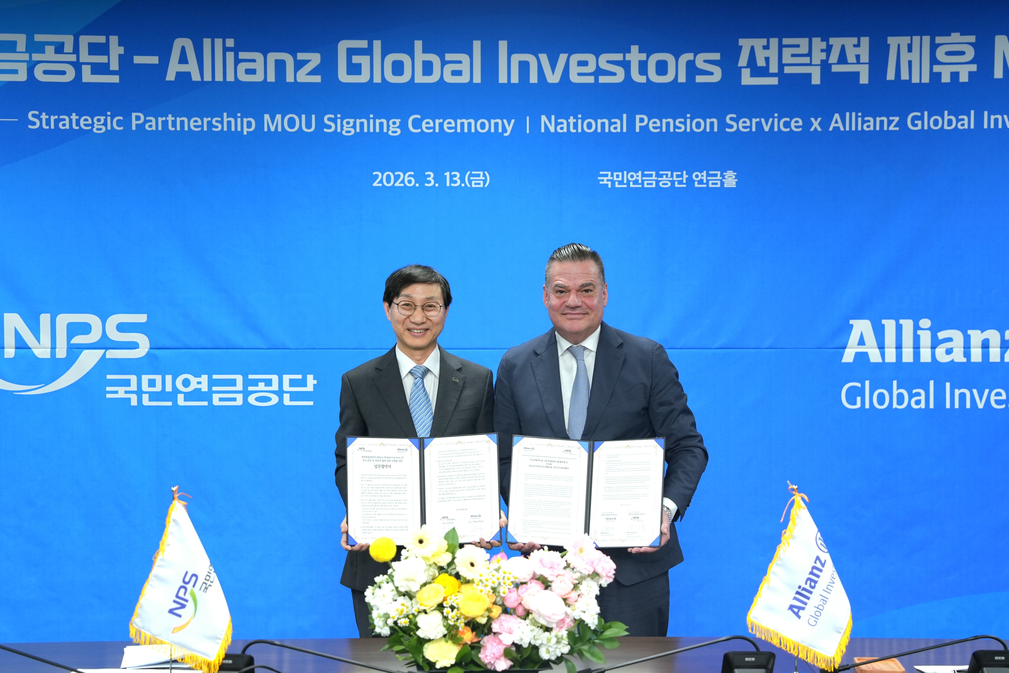 Chairman Kim and CEO Pross holding the signed MOU after the signing ceremony.