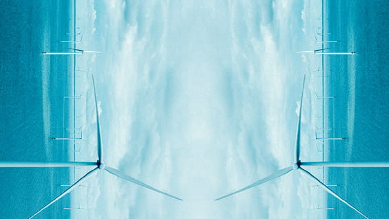 a mirrored image of a group of windmills in the sea